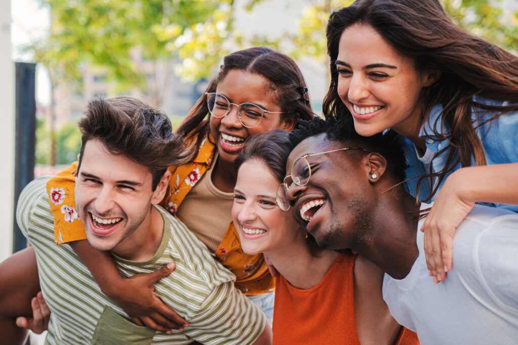 Group of college aged students smiling and posing for photo together